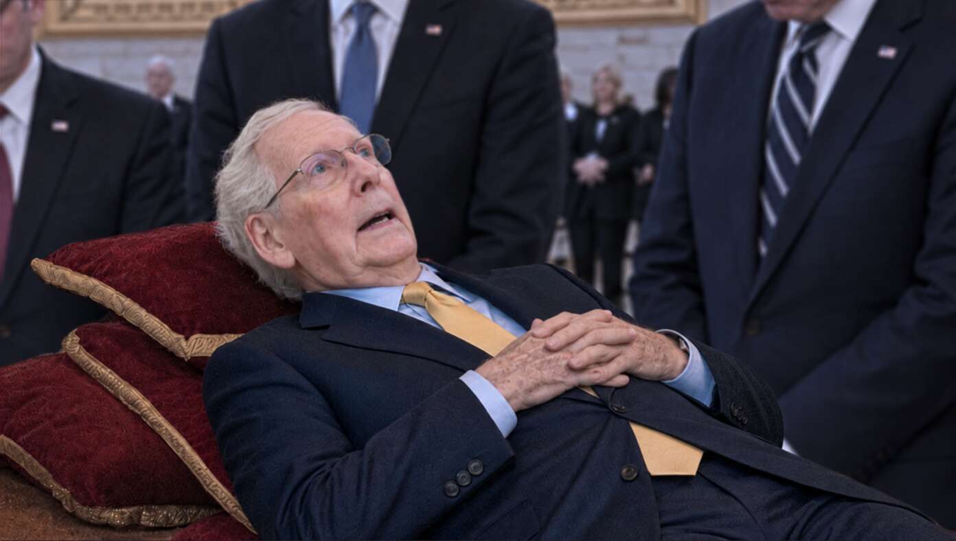 Mitch McConnell lying on a bed in the U.S. Capitol Rotunda.